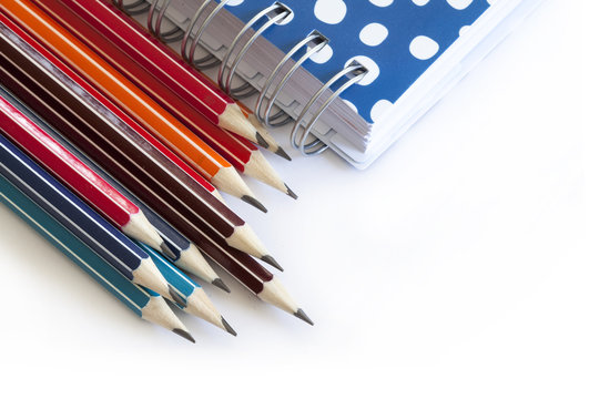 Colorful pencils on white background and  notebook