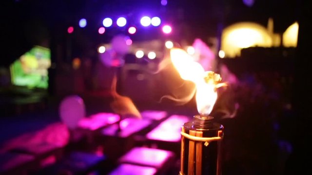 Inquadratura fiaccola accesa di fronte ad un palco per un concerto prima della festa. 