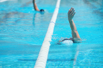 Women swimming backstroke in a race in the pool