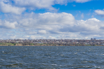 blue sea and sky. The ship sails past the coast with the settlement and now.