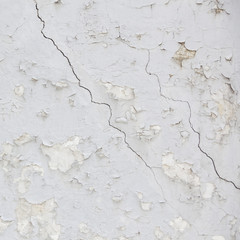 Fototapeta premium part of old wheathered white stucco full of cracks on outside wa