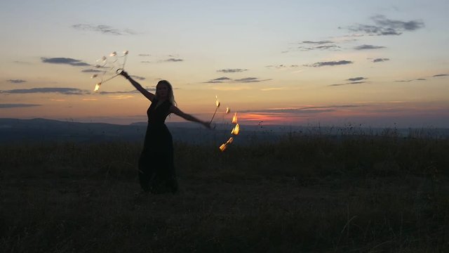 Fire, sunset sky and dancing with the fire girl