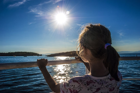 Little girl watching the sunset from boat. Croatia, Rab Island.