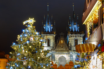 Naklejka premium Old Town Square with Christmas tree and fairy tale Church of our Lady Tyn in the magical city of Prague at night, Czech Republic