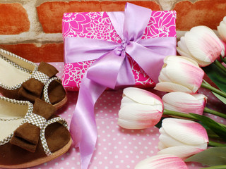 Fototapeta na wymiar pink gift box and ladies shoes on pink polka dot background