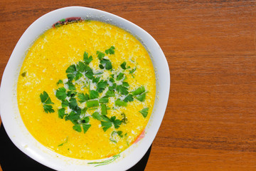 Soup with green parsley on wooden table