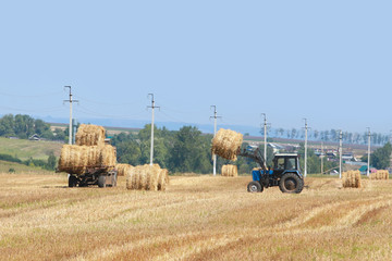 Menzelinsk, Russia - August 7, 2014: Tractor straw stacks during