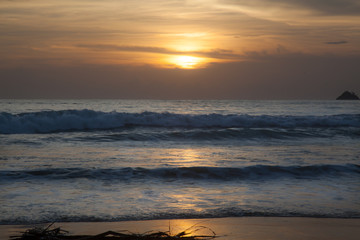 Sea waves at sunset .