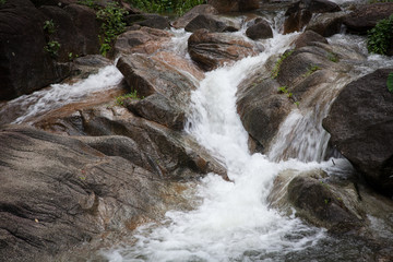 Mountain waterfall among stones .