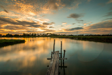 Wooded bridge in the port at sunset.