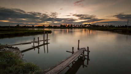 Wooded bridge in the port at sunset.