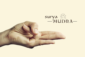 Image of woman hand in Surya mudra. Gesture is  isolated on toned background.