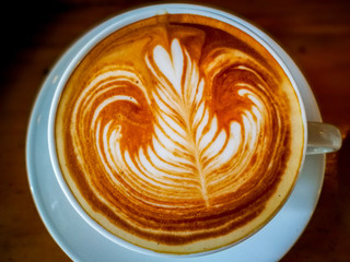 A Latte Coffee art on the wooden desk.selective focus of art latte.