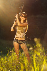 Young beautiful girl with a shotgun in an outdoor