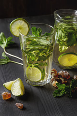 Mint iced tea with lime in the glass. Dark background.