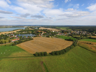 Fototapeta na wymiar aerial view of a small village with agricultural fields and lakes in germany