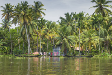 Naklejka na ściany i meble Unidentified indian people in small boat in Kerala backwaters.