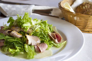 Fresh salad with boiled pork and mustard dressing