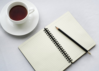 Coffee in white cup with Journal book and pencil