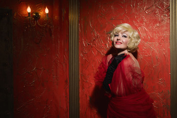 Fototapeta premium Pretty naked pinup blond girl model in a red room