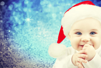 happy baby in santa hat over blue holidays lights