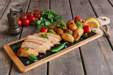 Chicken breast baked with tomato new potatoes and broccoli