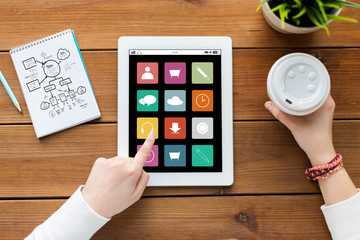 close up of woman with tablet pc on wooden table