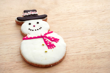 Snowman Cookie on Woodden Background. Christmas holiday treat.