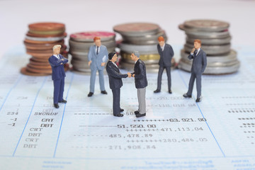 Business handshake and business people over money background , miniature people business man concept