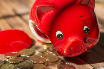 Zerbrochenes Sparschwein und Münzen