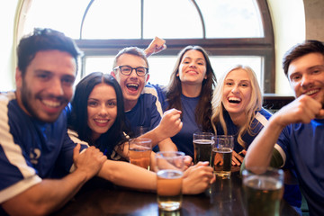 football fans or friends with beer at sport bar