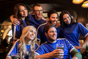 football fans or friends with beer at sport bar
