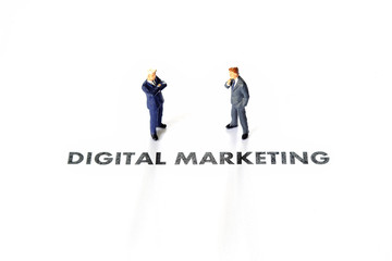 Miniature business man over digital marketing text