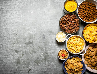 Various cereals in bowls. On stone table.
