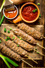 Kebab with green onions and hot sauce.