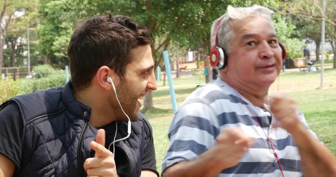 Father and son listening to music and having fun in the park