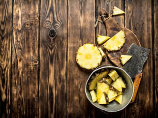 Slices of pineapple in a pot with an axe.