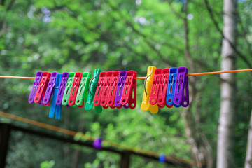 Fototapeta na wymiar colored clothes pegs hanging on a rope in the street