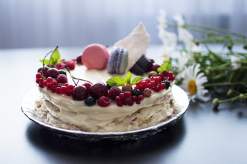 
Сладкий торт со свежими ягодами и пирожеными макаронс