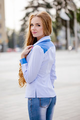 Beautiful brown-haired young woman wearing clothes and walking o