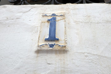 Numéro 1 bleu en relief sur mur blanc