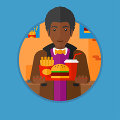Man with tray full of fast food.