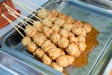 A skewer of grilled meatballs