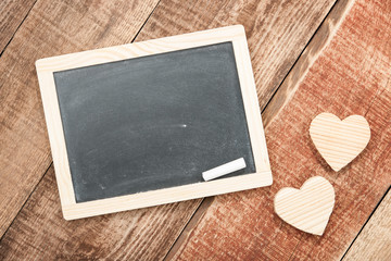 Wooden hearts and chalkboard on wood