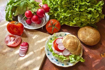 Sandwich with ham and vegetables on a rustic background