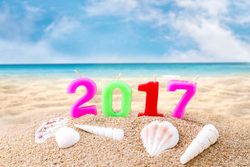 Colorful Candle Number 2 0 1 7 Over Blurred Blue Sea and Sand Beach with Clear Blue Sky ,Image for New Year 2017 Celebration Decorative Concept.