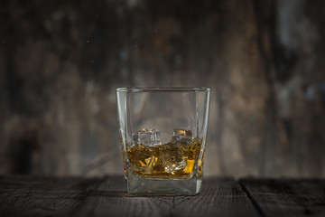 Whiskey glass on wooden table and wooden background