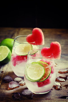 Refreshing drink with watermelon, soda and lime, dark wooden bac