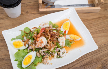 Thai style spicy salad on wood table.