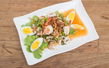 Thai style spicy salad on wood table.